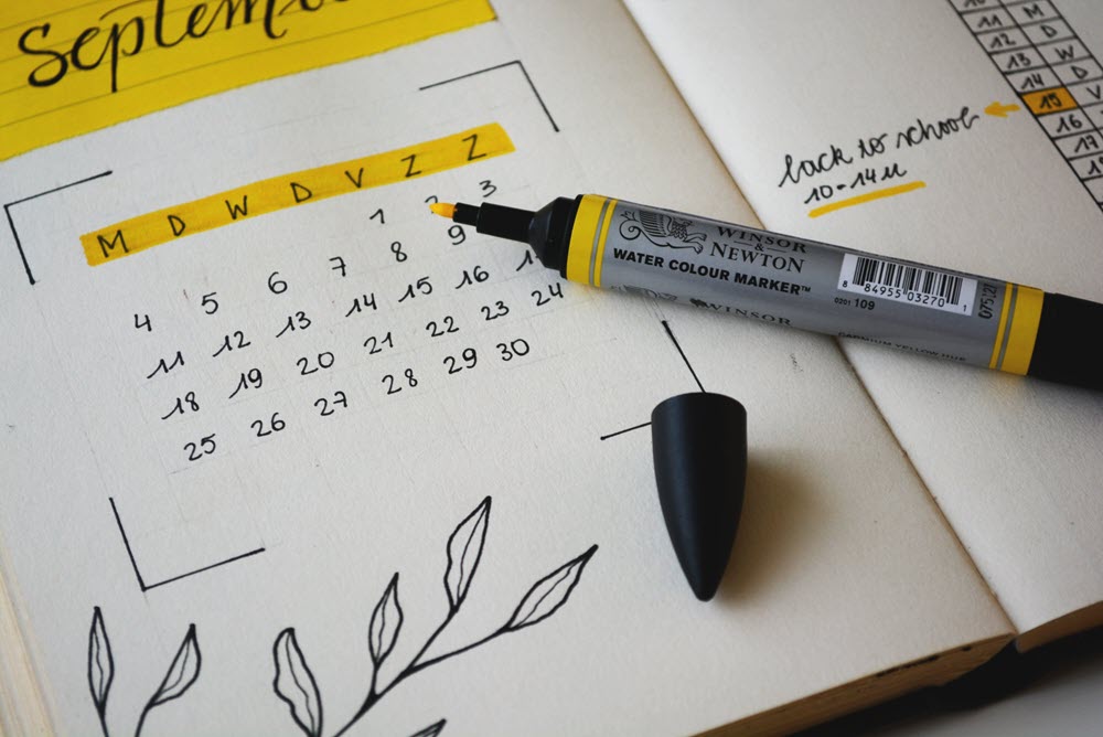 A pen and marker on top of a calendar.